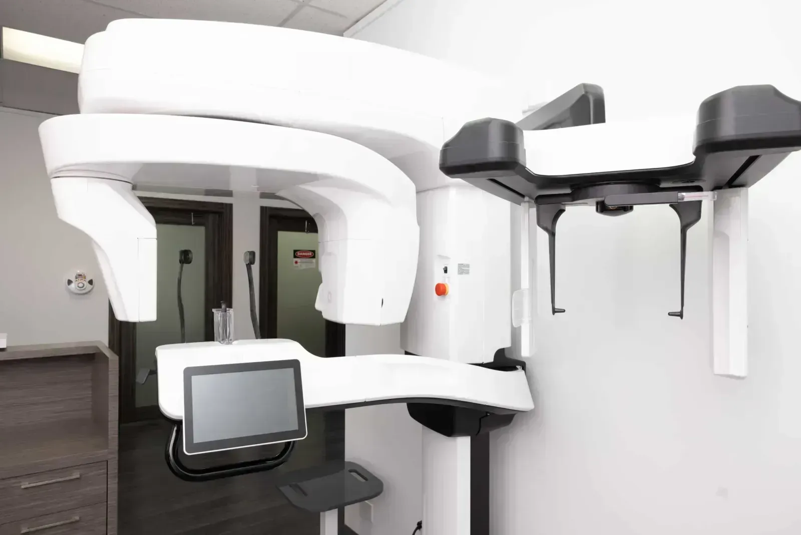 Dental cone beam CT scanner with touchscreen display and chin rest in clinic.